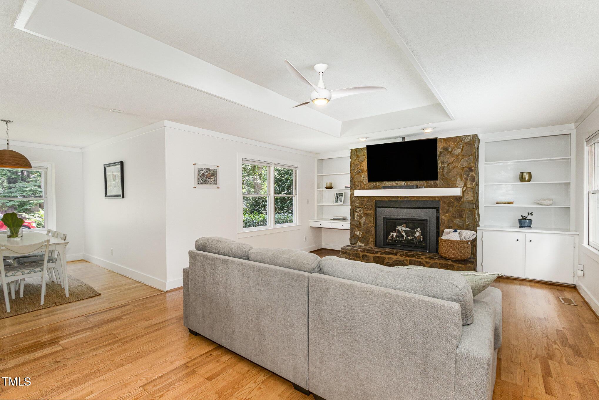 6025 Tarnhour Court Raleigh, NC 27612 - Photo 9 of 27 a living room with furniture a flat screen tv and a fireplace