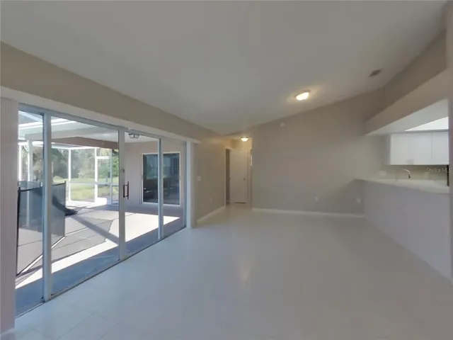 a view of an empty room with glass door and windows