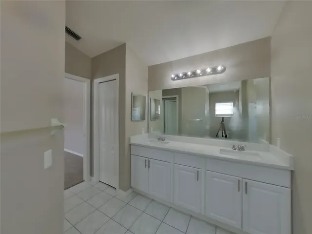 a bathroom with a double vanity sink and mirror