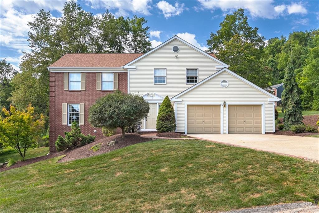 a front view of a house with a yard and garage