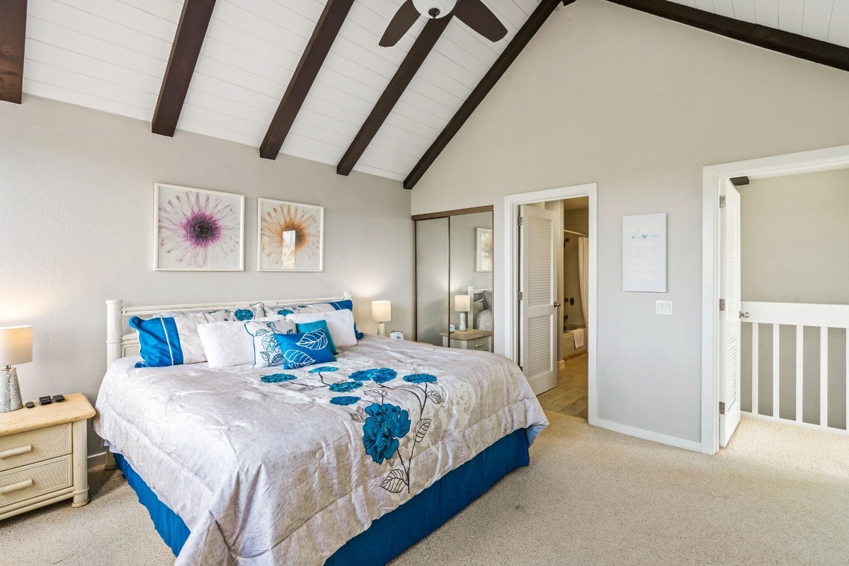 2370 Ho'ohu Road, Unit 522 Koloa, HI 96756 - Photo 18 of 29 a bedroom with bed and a chandelier