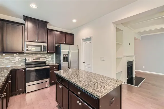 a kitchen with granite countertop wooden cabinets and stainless steel appliances
