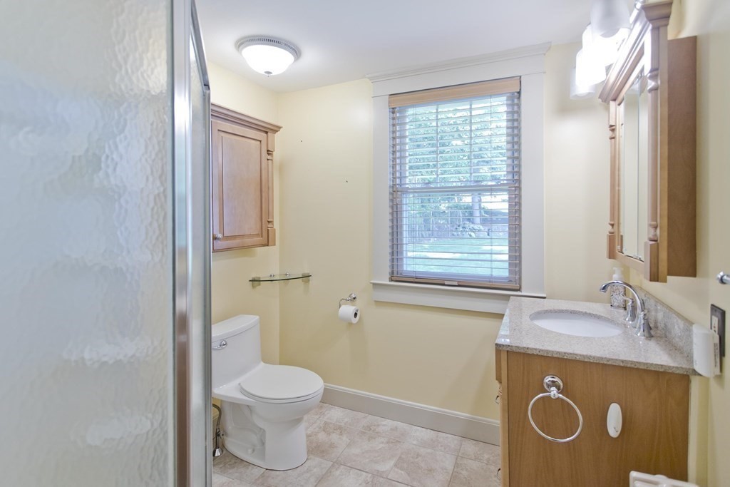144 Pasco Road Springfield, MA 01151 - Photo 12 of 42 a bathroom with a granite countertop toilet a sink and a mirror