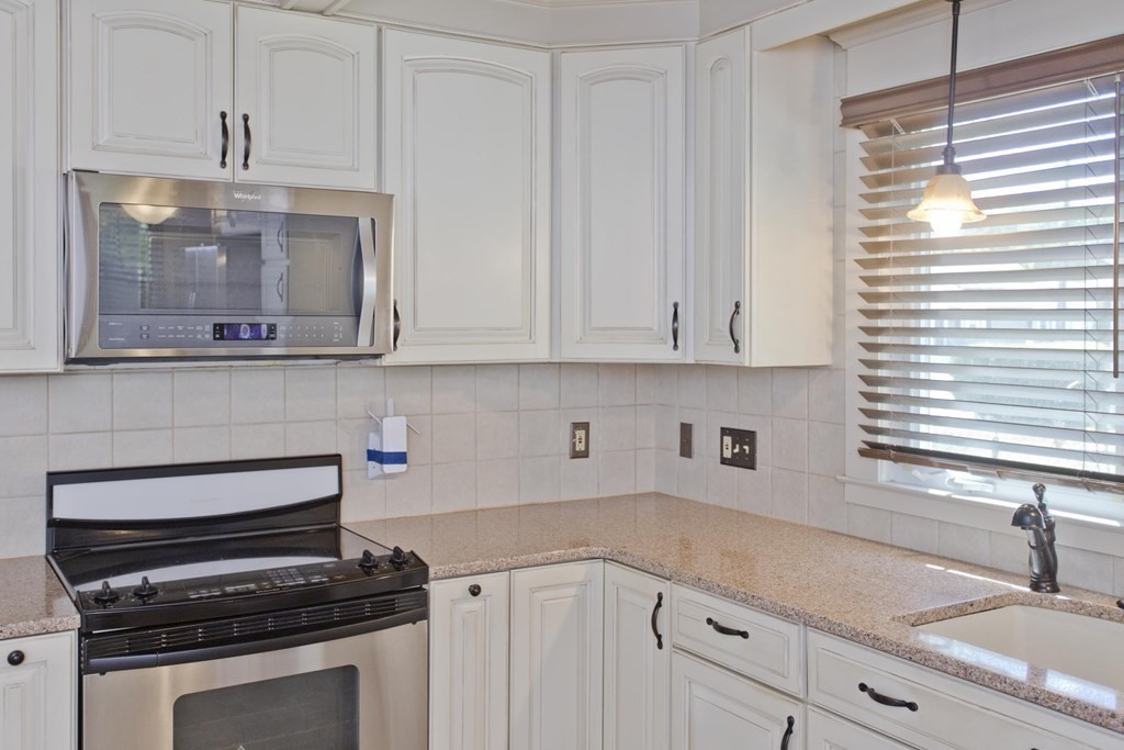 144 Pasco Road Springfield, MA 01151 - Photo 7 of 42 a kitchen with white cabinets and appliances