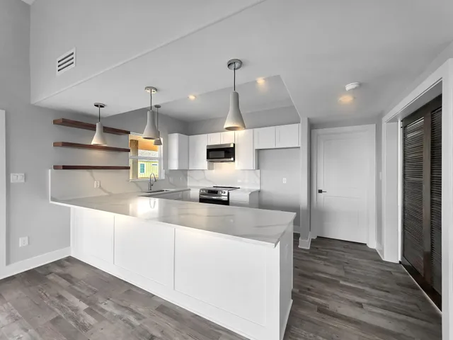 a large kitchen with stainless steel appliances kitchen island granite countertop a sink and a stove