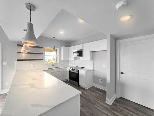 a view of an empty room with closet and a window