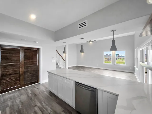 a kitchen with counter top space and wooden floor
