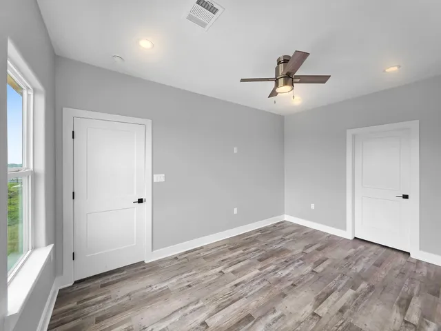 a view of a hallway with wooden floor and staircase