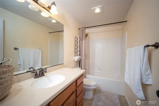 a bathroom with a granite countertop sink toilet a shower and a mirror