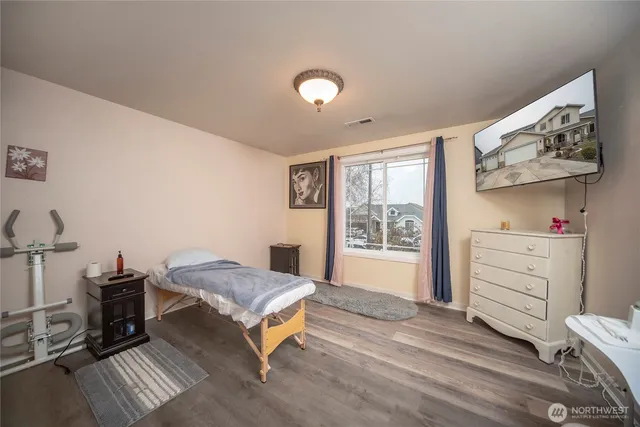 a bedroom with furniture and a wooden floor