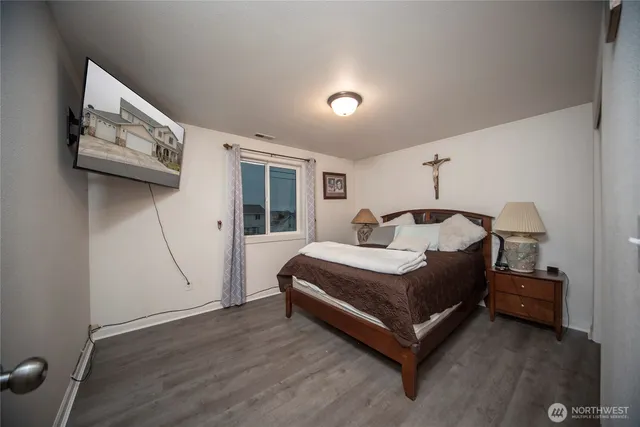 a bedroom with a bed and wooden floor