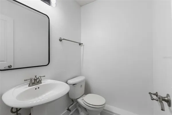 a bathroom with a toilet a sink and mirror
