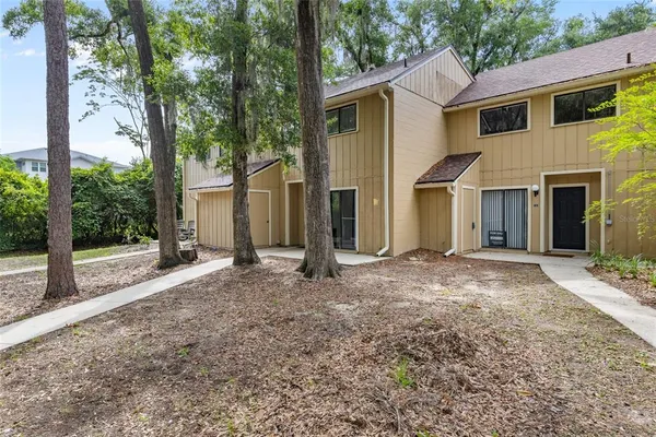 a view of a house with backyard and a tree