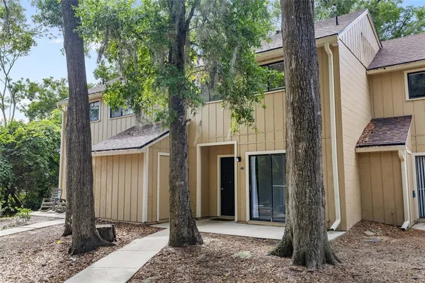 a front view of a house with a tree