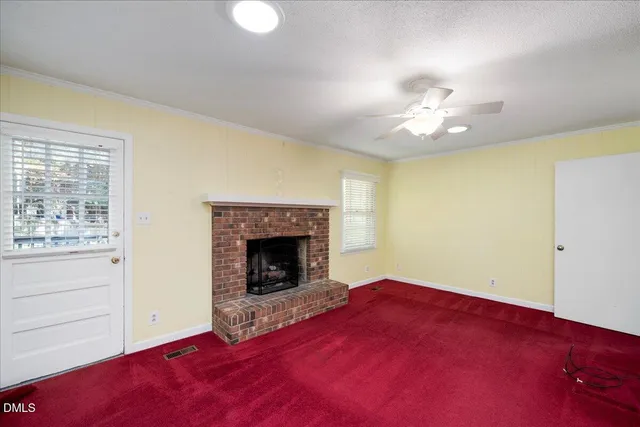 a view of empty room with fireplace and fan