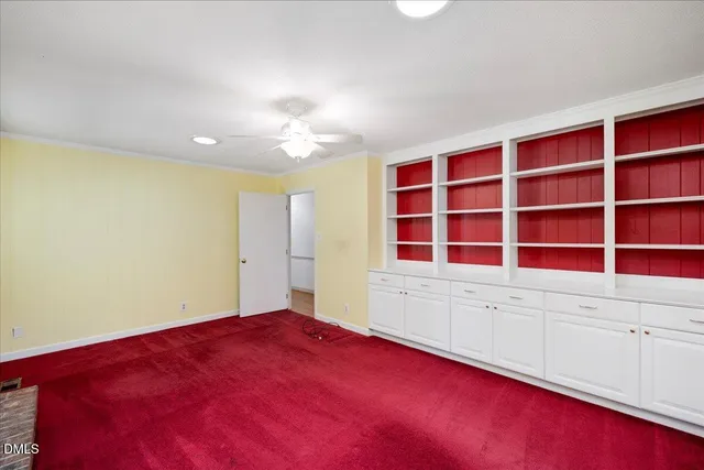 a view of empty room with window and cabinet