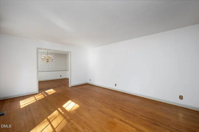 a view of a big room with wooden floor and windows