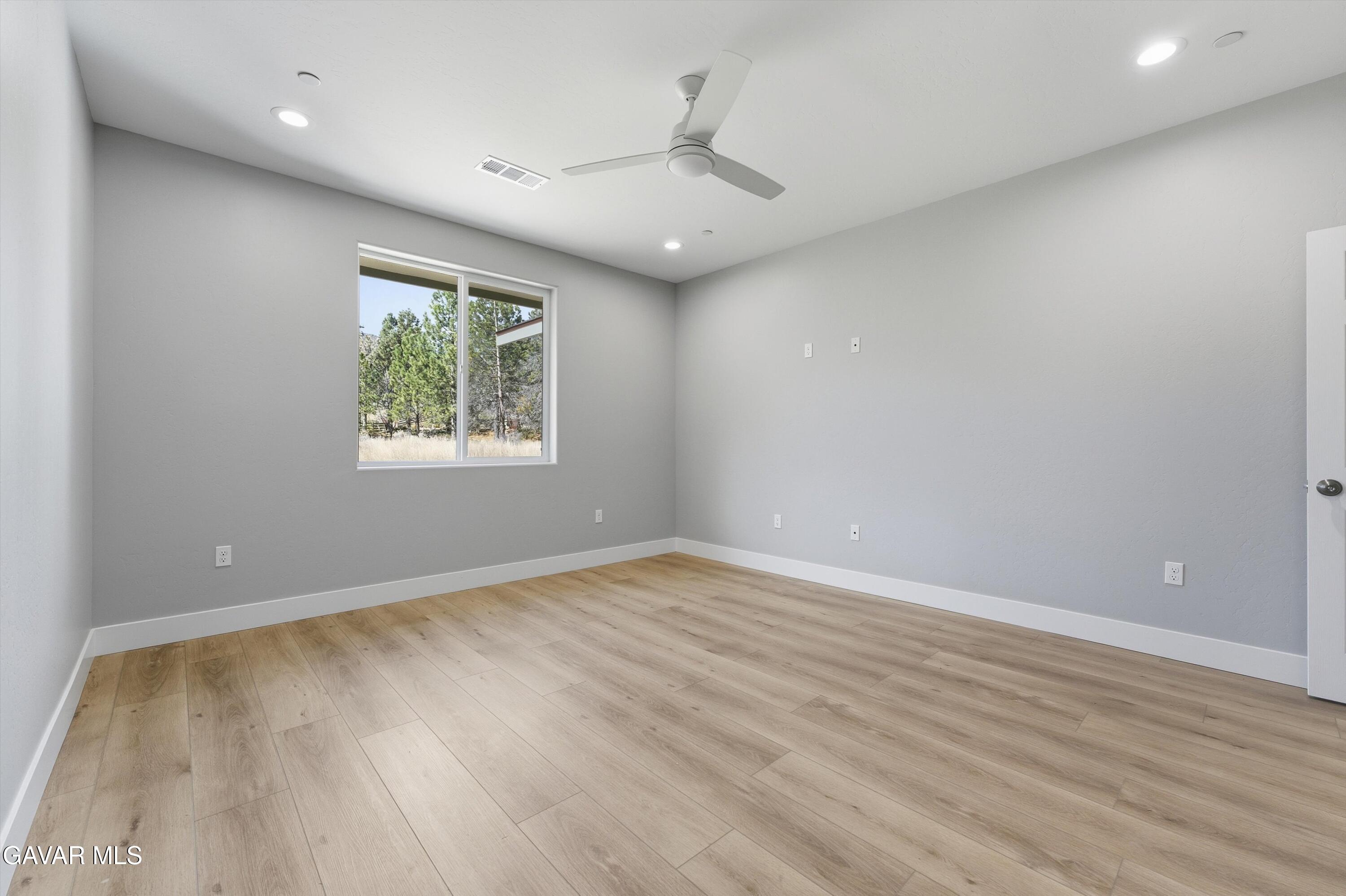 22613 Royal Place Tehachapi, CA 93561 - Photo 19 of 28 an empty room with wooden floor and windows