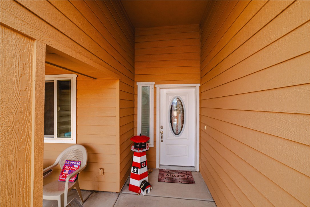 2948 Pinal Road Golden Valley, AZ 86413 - Photo 58 of 59 Front entry featuring a white oval-lite door, a vertical sidelite, and durable horizontal siding