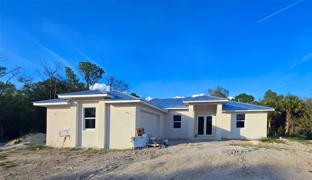 a view of a white house with a yard