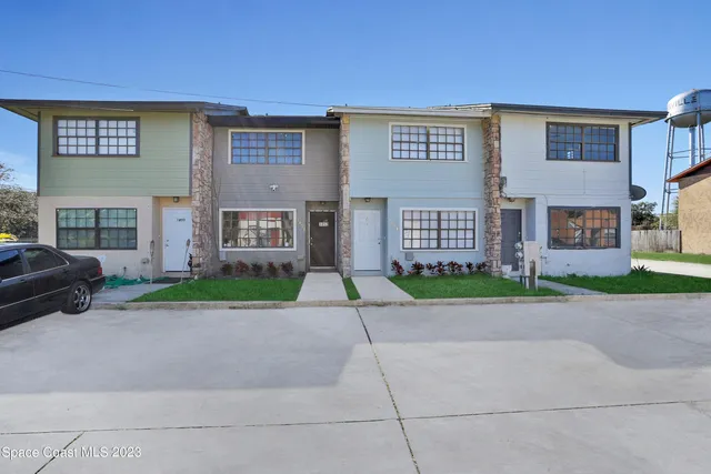a view of a brick house with a yard and large windows
