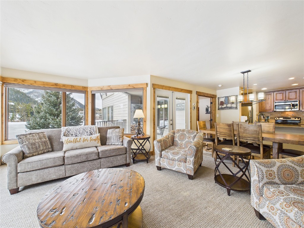 22280 Highway 6, Unit 1709 Keystone, CO 80435 - Photo 5 of 49 Open-concept living and dining area with large windows, patio access, and abundant natural light.