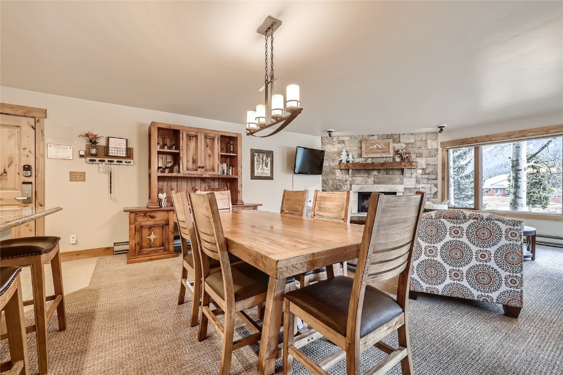 22280 Highway 6, Unit 1709 Keystone, CO 80435 - Photo 8 of 49 Warm dining area with rustic wood table, generous seating, and open flow to the living roomideal for gathering and entertaining.