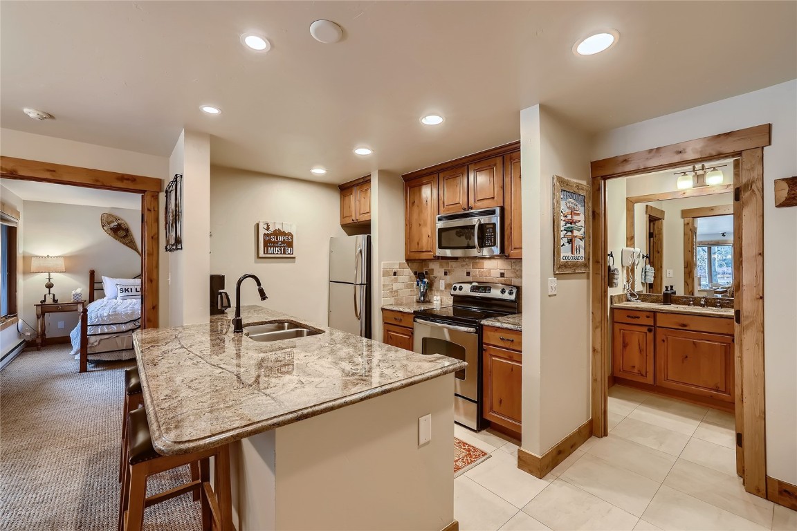 22280 Highway 6, Unit 1709 Keystone, CO 80435 - Photo 9 of 49 Updated kitchen with granite countertops, stainless steel appliances, breakfast bar seating, and warm wood cabinetry.