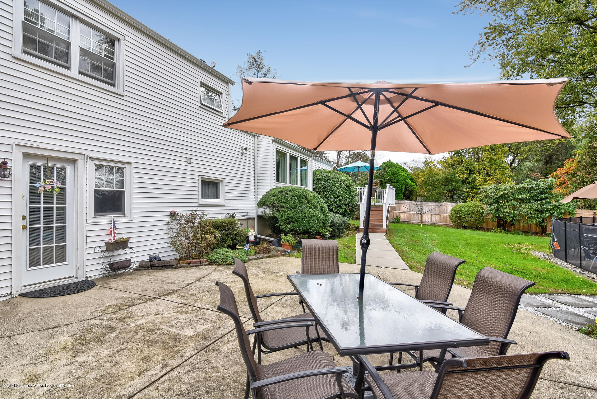 25 Gull Road Middletown, NJ 07748 - Photo 35 of 38 a view of a patio with table and chairs under an umbrella