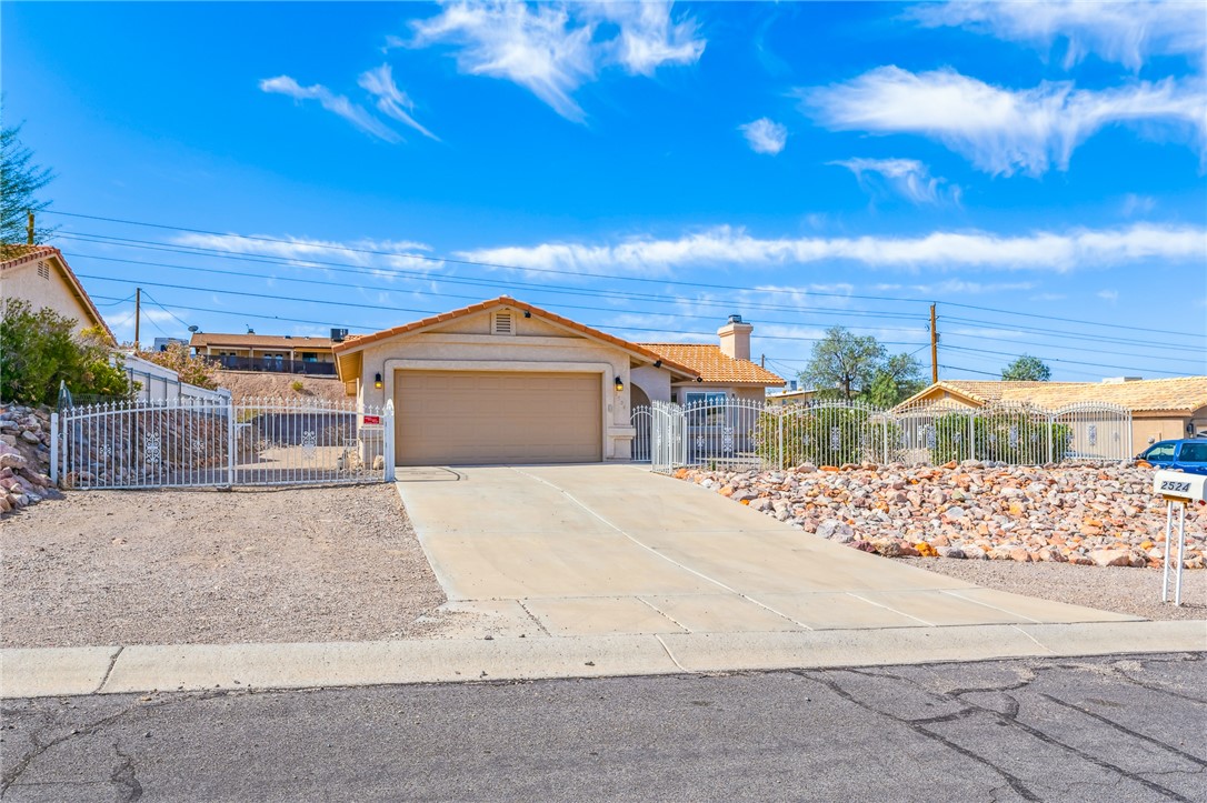 2524 South Ridge Avenue Bullhead City, AZ 86429 - Photo 3 of 64 Single story home with a fenced front yard, a garage, a chimney, and driveway
