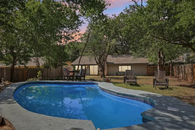 a view of a house with backyard sitting area and tree