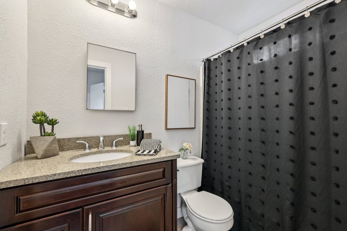 602 Old Stone Road Austin, TX 78745 - Photo 14 of 28 a bathroom with a granite countertop sink toilet and mirror