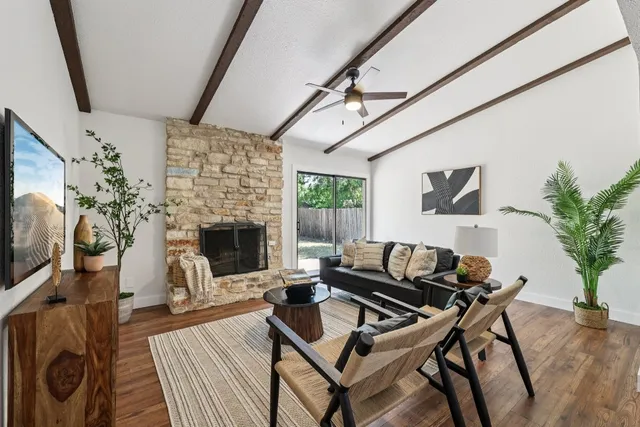 a living room with furniture a flat screen tv and a fireplace