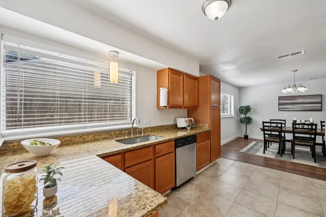 a kitchen with stainless steel appliances granite countertop a stove a sink a table and chairs