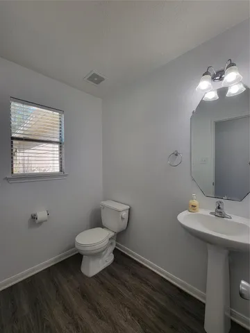 a bathroom with a toilet sink and a mirror