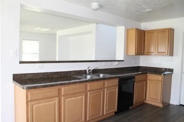 a kitchen with granite countertop a sink and cabinets