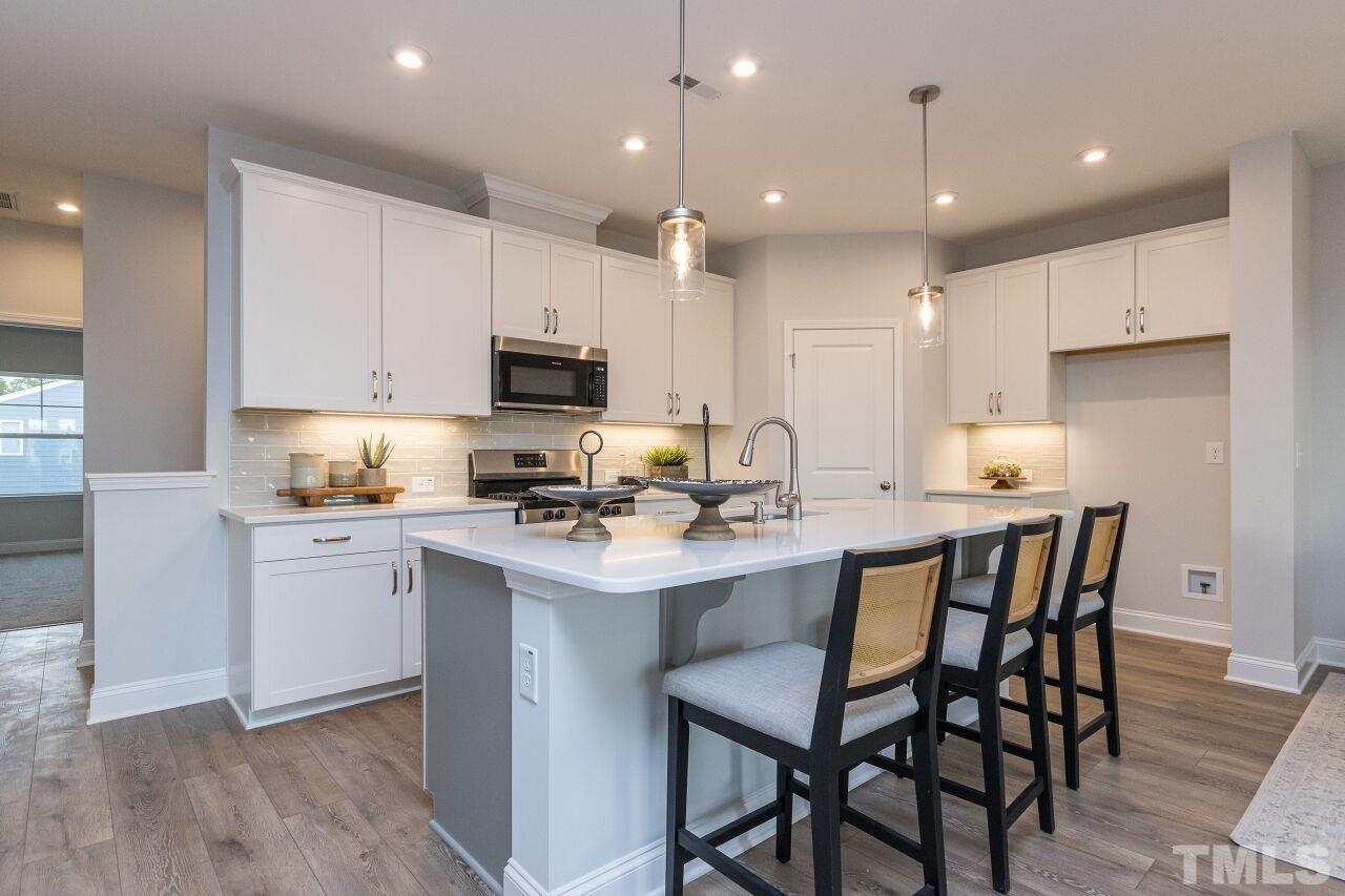 a kitchen with kitchen island granite countertop a sink and white appliances