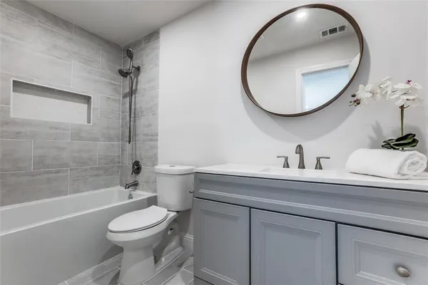 a bathroom with a toilet a sink a mirror and bathtub