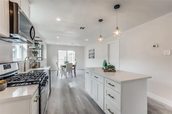 a kitchen with white cabinets and stove