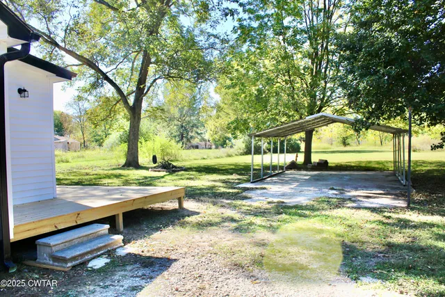 a view of a house with backyard and a tree