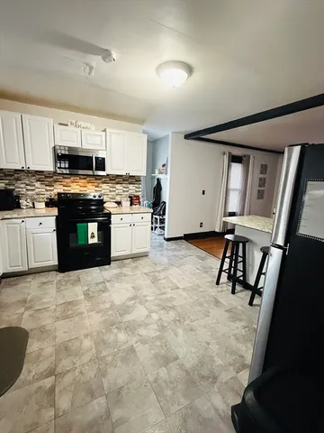 a kitchen with stainless steel appliances granite countertop a stove sink and cabinets
