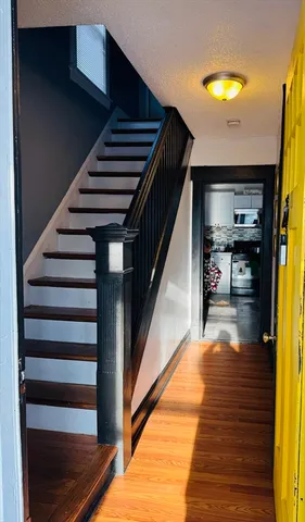 a view of entryway and hall with wooden floor