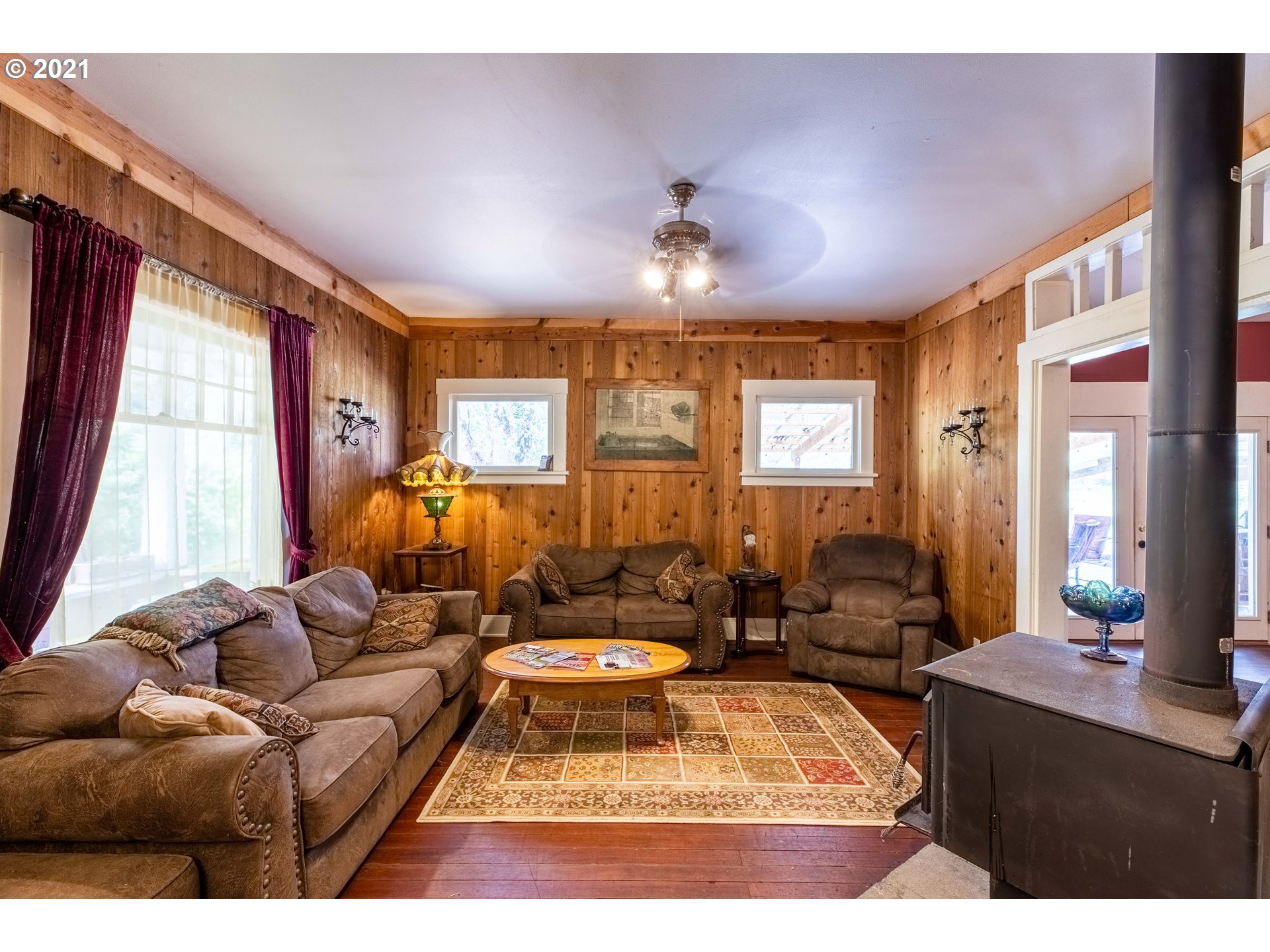 438 Soup Creek Road Reedsport, OR 97467 - Photo 13 of 30 a living room with furniture chandelier and large window