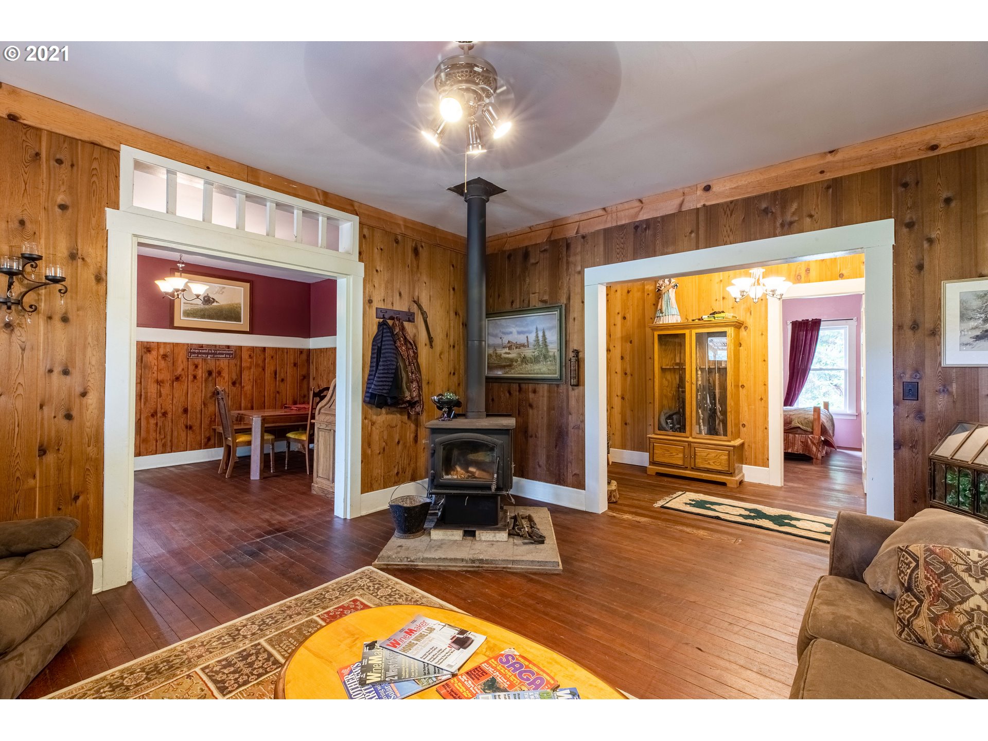 438 Soup Creek Road Reedsport, OR 97467 - Photo 14 of 30 a living room with furniture a dining table and a large window with wooden floor