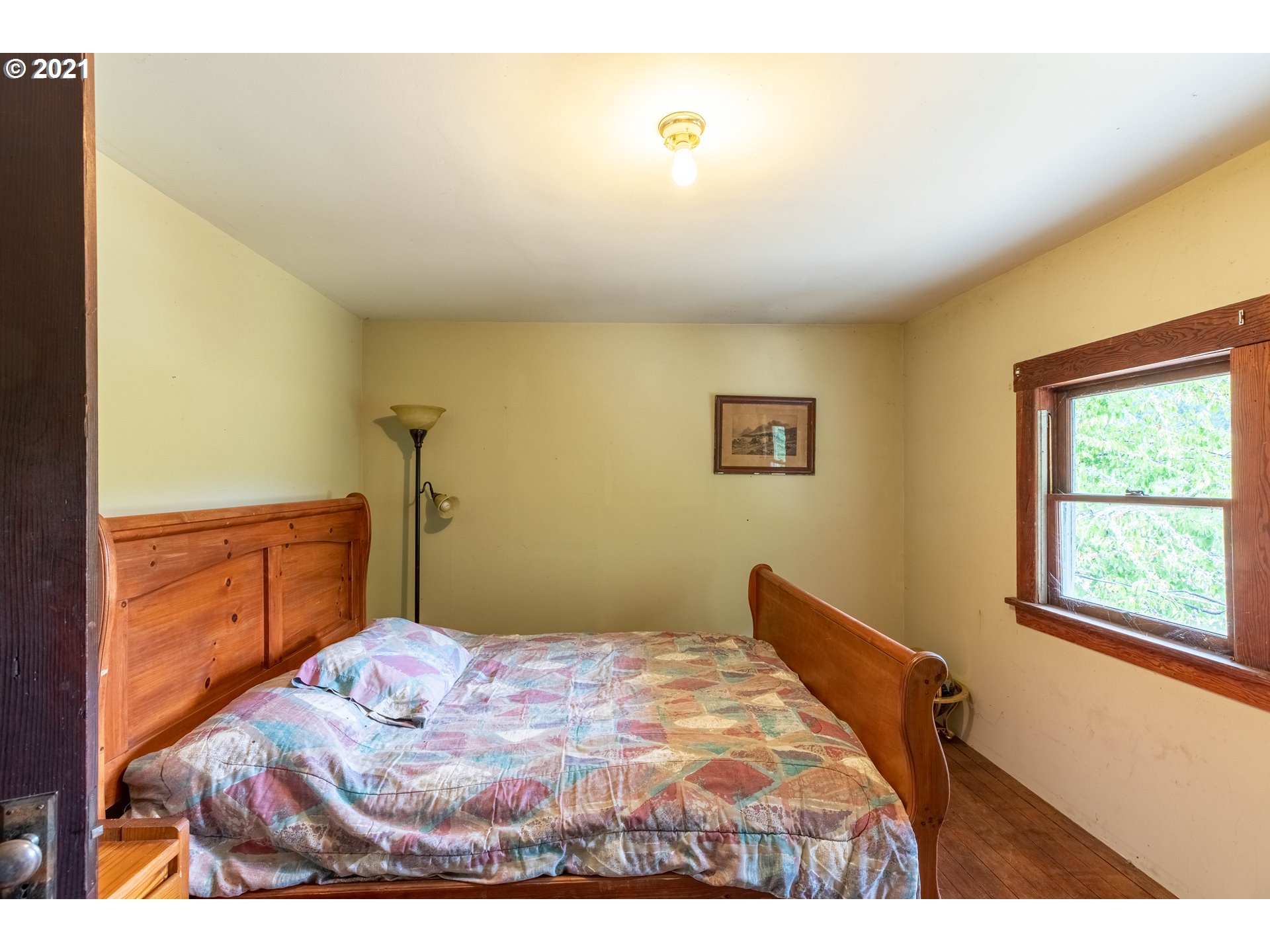 438 Soup Creek Road Reedsport, OR 97467 - Photo 26 of 30 a bedroom with a bed and a window