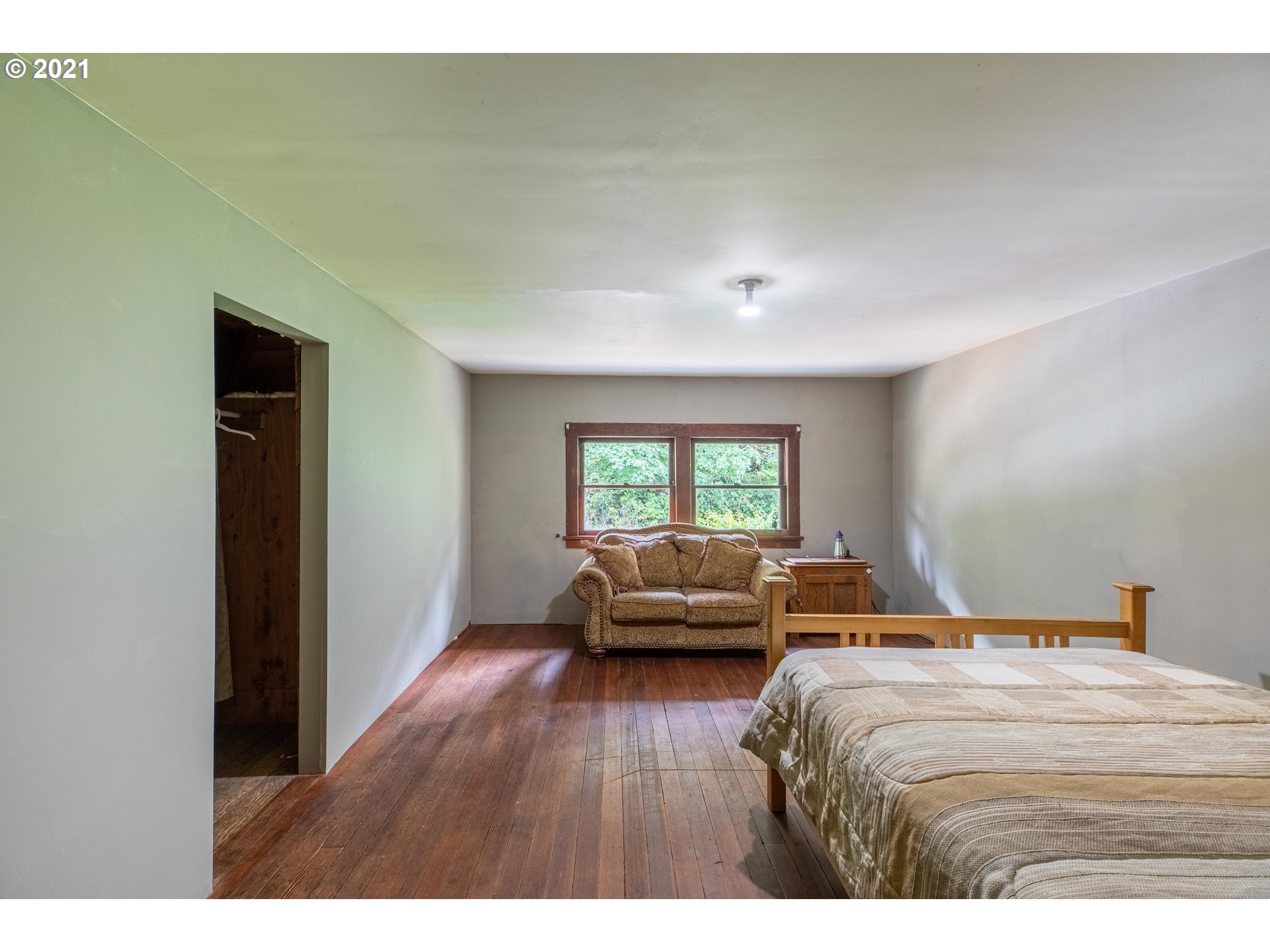 438 Soup Creek Road Reedsport, OR 97467 - Photo 28 of 30 a bedroom with a bed and wooden floor