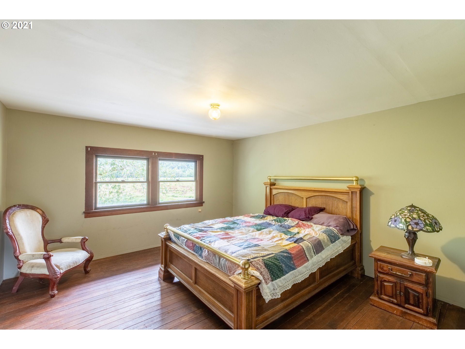 438 Soup Creek Road Reedsport, OR 97467 - Photo 29 of 30 a bedroom with a bed chair and a window