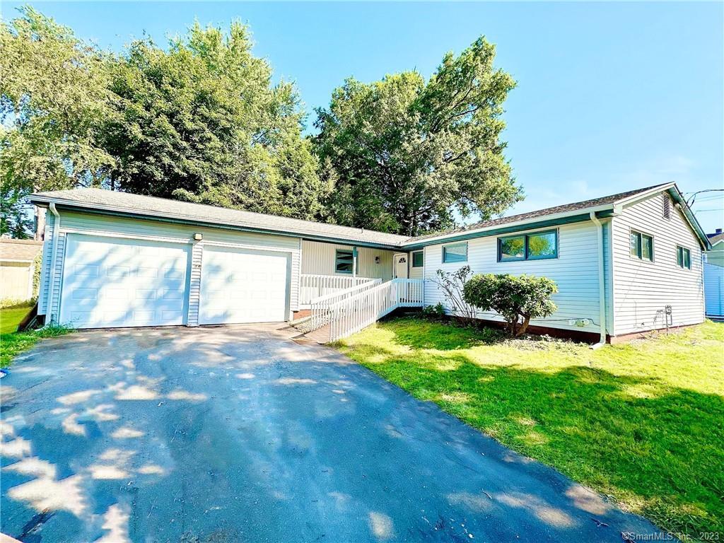 a view of a house with backyard and a tree