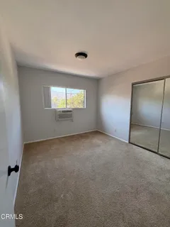 an empty room with windows and closet