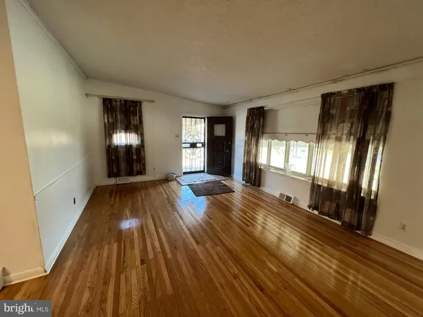 a view of a room with wooden floor and windows